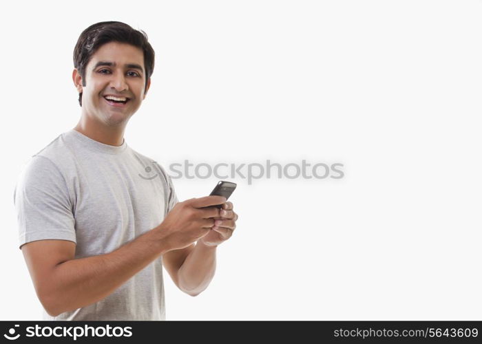 Cheerful young man holding cell phone over white background