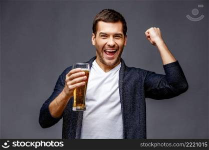 Cheerful young man in smart casual wear against grey background. Cheerful young man in smart casual wear