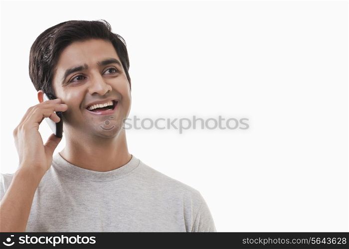 Cheerful young man on phone call over white background