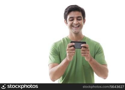 Cheerful young man texting over white background