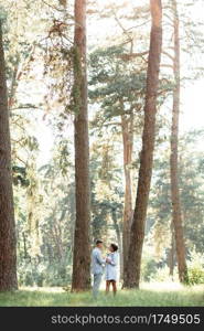 Cheerful young woman and man are hugging outdoors in summer park. Dating and romantic vacation. couple in love gently looking at each other on sunny day. Love and relationships between young people.. Cheerful young woman and man are hugging outdoors in summer park. Dating and romantic vacation. couple in love gently looking at each other on sunny day. Love and relationships between young people