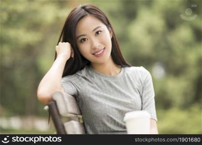 Cheerful young woman drinking coffee outdoors