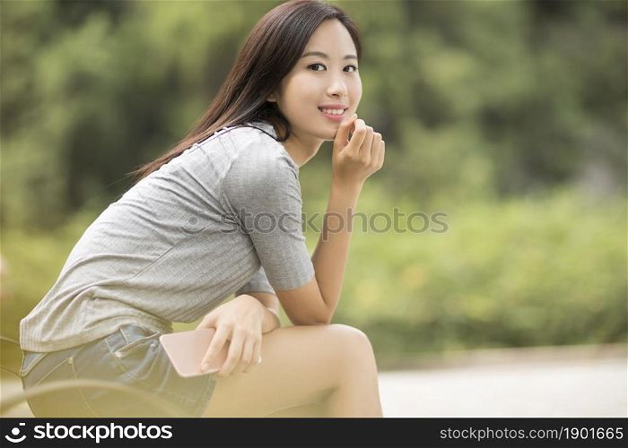 Cheerful young woman holding her phone