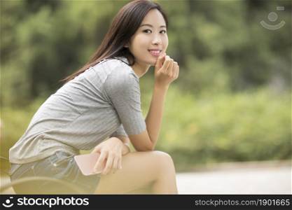 Cheerful young woman holding her phone