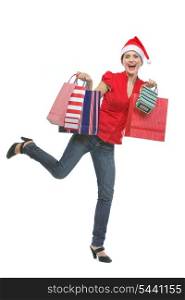 Cheerful young woman in Santa hat holding shopping bags