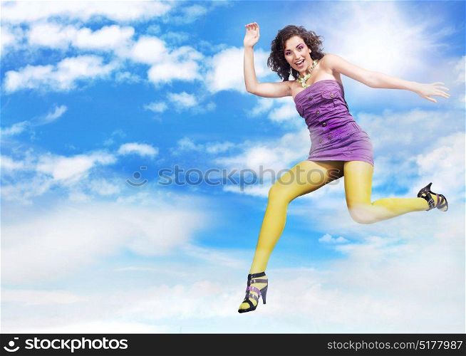 Cheerful young woman jumping up to the sky