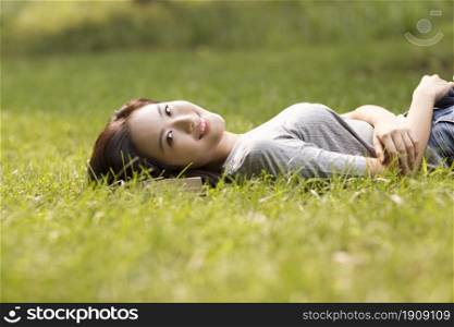 Cheerful young woman lying on the lawn