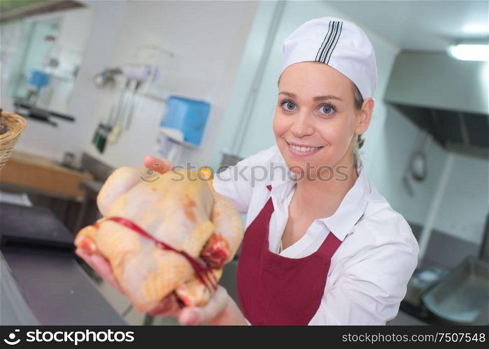 cheerful young woman selling fresh chicken
