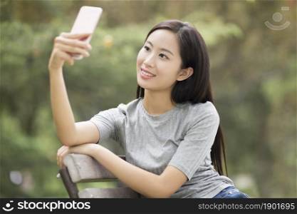 Cheerful young woman taking selfies with her phone