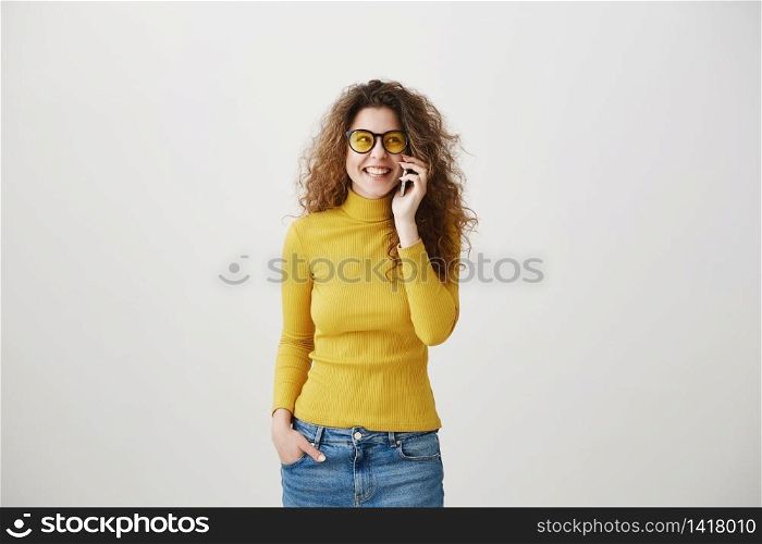 Cheerful young woman talking on mobile phone isolated on gray background. Cheerful young woman talking on mobile phone isolated on gray background.