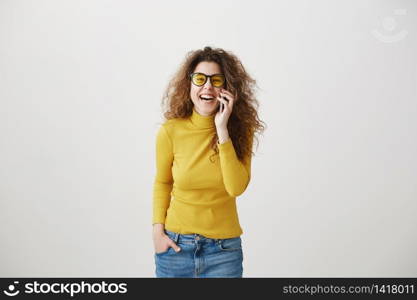 Cheerful young woman talking on mobile phone isolated on gray background. Cheerful young woman talking on mobile phone isolated on gray background.