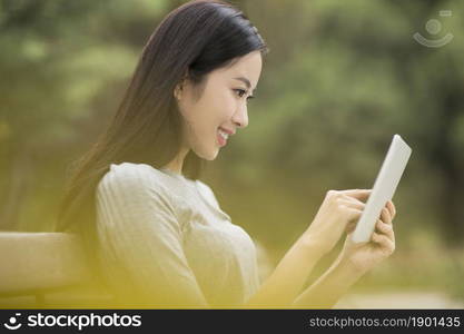 Cheerful young woman using her tablet computer