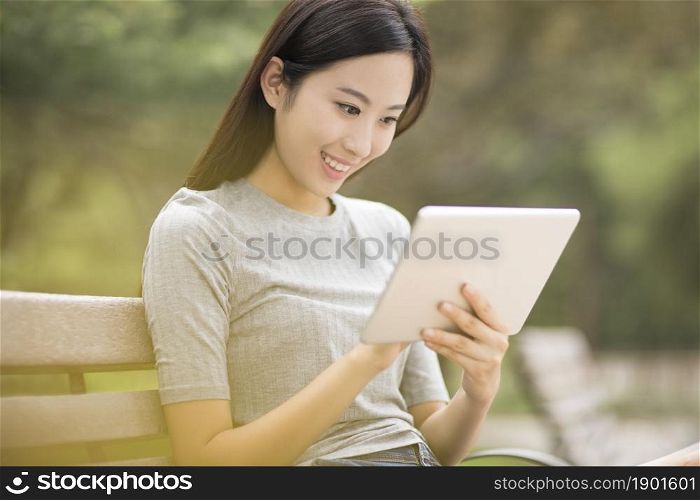 Cheerful young woman using her tablet computer