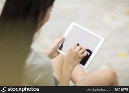 Cheerful young woman using her tablet computer