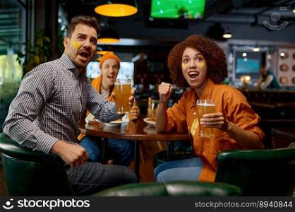 Cheering friends of soccer fans in pub. Multiracial diverse group of young people with funny makeup in faces watching game on screen in sports bar cheering for favorite team during football festival. Cheering friends of soccer fans with creative makeup in faces in pub