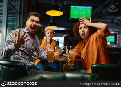 Cheering friends of soccer fans in pub. Multiracial diverse group of young people with funny makeup in faces watching game on screen in sports bar cheering for favorite team during football festival. Cheering friends of soccer fans with creative makeup in faces in pub