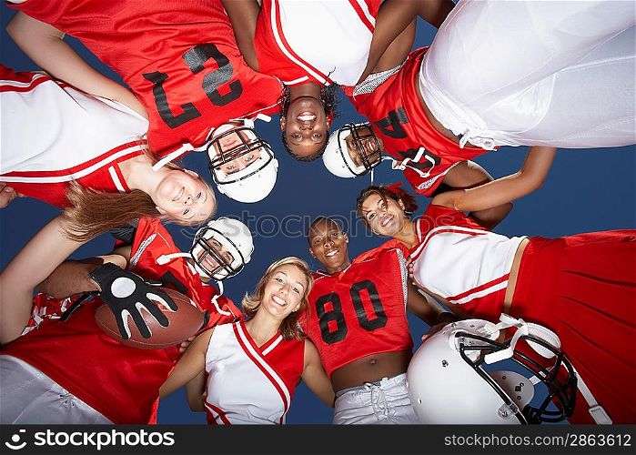 Cheerleaders and Football Players in Huddle