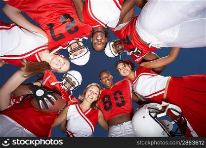 Cheerleaders and Football Players in Huddle
