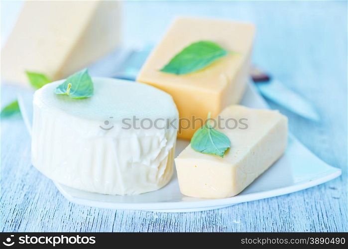 cheese and basil on the plate and on a table
