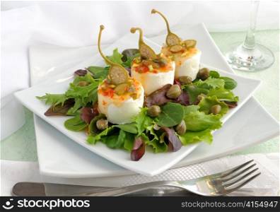 Cheese and capers sweet and sour sauce and pistachios in green leaves