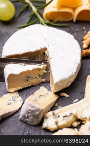 Cheese and grape and nuts on a slate board. Cheese delicious plate