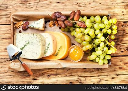 cheese and grapes. Cheese with coriander and grapes on retro wooden background