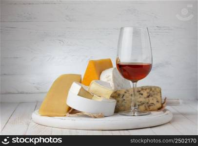 Cheese and red wine on wooden table still life