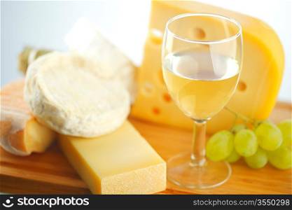 cheese and wine on a wooden table