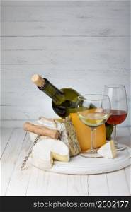 Cheese and wine on wooden table still life