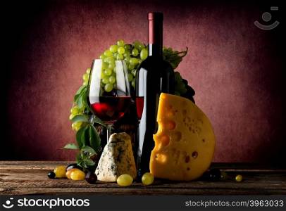Cheese and wine with grape on vinous background
