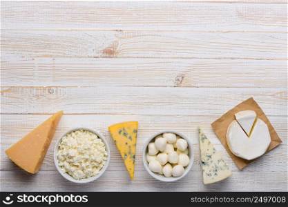 Cheese assortment on white wooden table top view flat lay