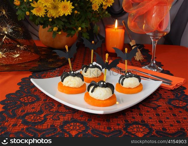 Cheese balls with olives spiders and bats on a festive table