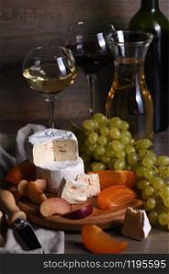 Cheese brie, camembert with white grapes, sliced persimmons and plums, a great appetizer for wine