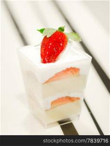 cheese cake with strawberries, decorated with fresh strawberries , served in a bowl with a small