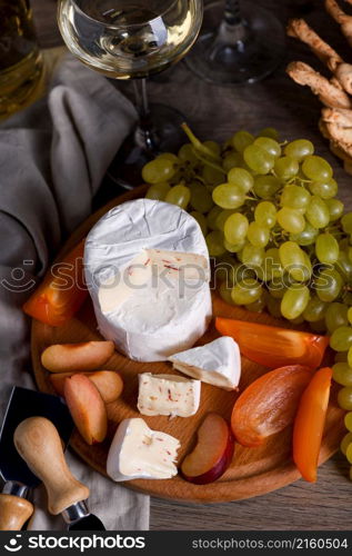 Cheese camembert with white grapes, sliced persimmons and plums, a great appetizer for wine