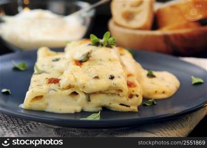 Cheese cannelloni pasta served on a plate with alfredo sauce
