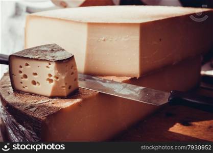 cheese on a wooden table with knife