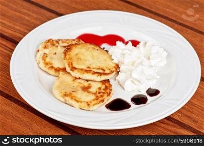 Cheese pancakes. Cheese pancakes with sour cream and berry jam