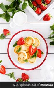 Cheese pancakes, fritters or syrniki with fresh strawberry and yogurt. Healthy and tasty breakfast