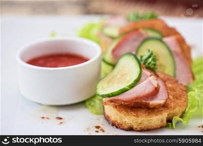 Cheese pancakes. pancakes with ham and cucumber with tomato sauce and lettuce