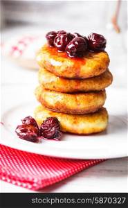 cheese pancakes with cherry jam on the plate. cheese pancakes