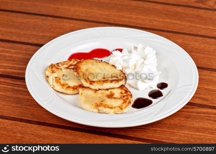 Cheese pancakes with sour cream and berry jam