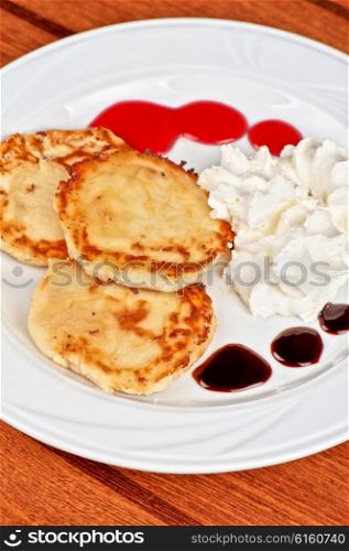 Cheese pancakes with sour cream . Cheese pancakes with sour cream and berry jam