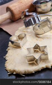 Cheese pastry dough with rolling pin on dark background