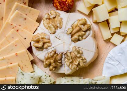 Cheese plate variation on a wooden table.. Cheese plate variation on a wooden table