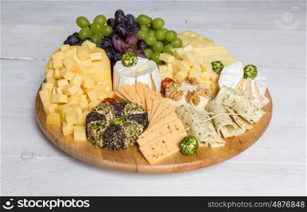 Cheese plate variation on a wooden white table. Cheese plate variation on a wooden white table.