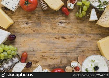 cheese platter with tomatoes grapes mini sandwiches wooden desk with space writing text
