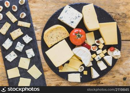 cheese platter with tomatoes mini sandwich black slate wooden table