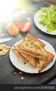 Cheese sandwich with tomato and green lettuce. Cheese sandwich