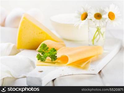 cheese slices with parsley on wooden table